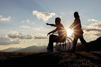 Pflegerin mit Patientin im Rollstuhl